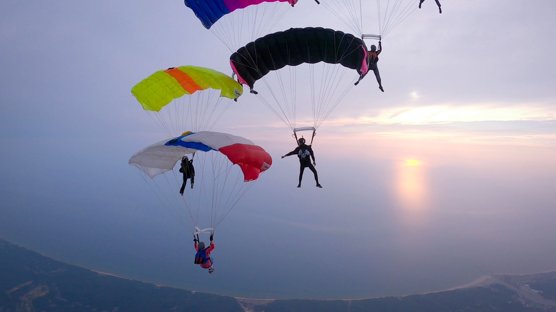 Group of my friends making a formation with our parachutes in the sky.